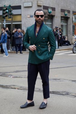 MILAN, İtalya - 24 Şubat 2024: Dolce ve Gabbana moda defilesinden önce yeşil ceketli ve siyah şortlu adam, Milan Moda Haftası tarzı