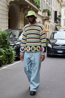 MILAN, ITALY - 14 Haziran 2024: yeşil şapkalı, turkuaz pantolonlu ve çizgili süveterli Josh Okogie Milyarder moda defilesi, Milan Moda Haftası tarzı