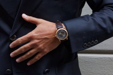 MILAN, ITALY - 14 Haziran 2024: Milyarder moda defilesinden önce Patek Philippe Dünya Saati İzleyen Adam, Milyarder Moda Haftası tarzı
