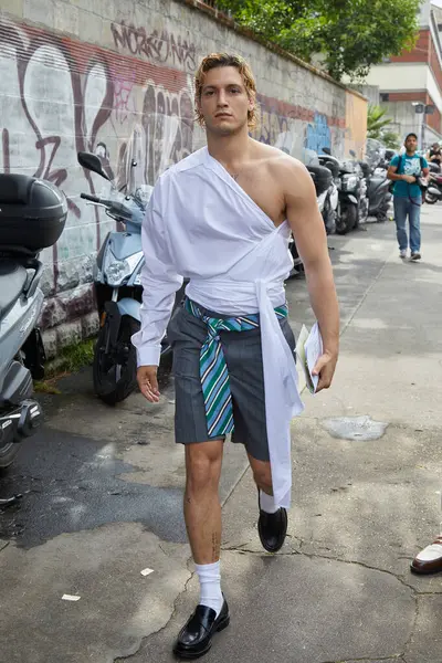 stock image MILAN, ITALY - JUNE 14 , 2024: Gabriele Esposito with white asymmetric shirt and gray shorts before Moschino fashion show, Milan Fashion Week street style