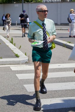 MILAN, İtalya - 16 Haziran 2024: Prada moda defilesinden önce yeşil tişörtlü ve şortlu adam, Milan Moda Haftası tarzı