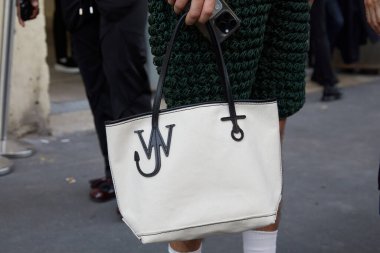 MILAN, ITALY - 16 Haziran 2024 JW Anderson defilesinden önce beyaz ve siyah çantalı adam, Milan Moda Haftası tarzı
