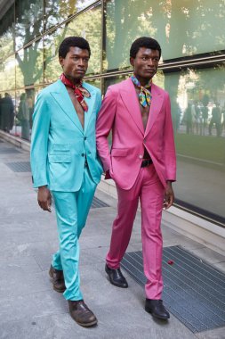MILAN, ITALY - 17 Haziran 2024: Turkuaz ve pembe takım elbiseli adamlar Giorgio Armani defilesinden önce, Milan Moda Haftası tarzı