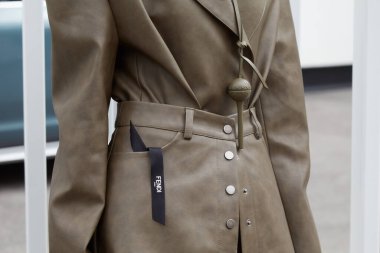 MİLAN, İTALYA 17 Eylül 2024: Gri kahverengi deri elbiseli kadın Fendi defilesinden önce, Milano sokak tarzı