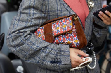 MILAN, İtalya - 17 Eylül 2024: Alberta Ferretti defilesinden önce Fendi çantalı, turuncu, mavi ve sarı desenli bir kadın, Milano sokak tarzı