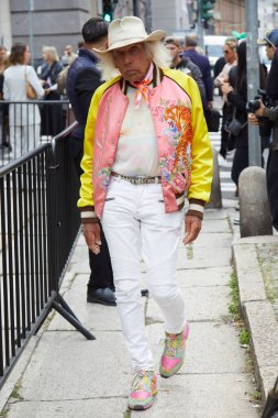 MILAN, İtalya - 18 Eylül 2024: Boss defilesinden önce pembe ve sarı Balmain bombacı ceketli adam, Milano sokak tarzı