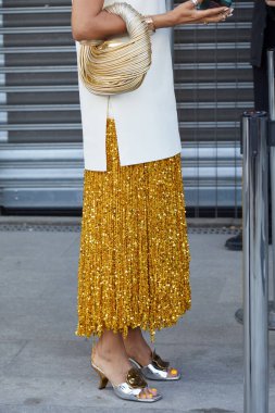 MİLAN, İTALYA 19 Eylül 2024: Altın pullu etekli ve gümüş topuklu ayakkabılı kadın Felsefe defilesinden önce, Milano sokak tarzı