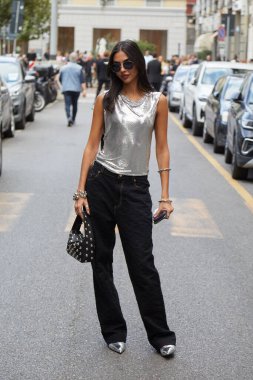 MİLAN, İTALYA 19 EPTEMBER 2024: Gümüş atlet, siyah pantolon ve siyah deri çantalı kadın Maison Margiela defilesinden önce, Milan sokak stili