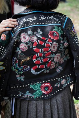 MİLAN, İTALYA 20 EYLÜL 2024: Gucci defilesinden önce siyah deri ceketli, çiçekli, çivili ve yamalı bir kadın, Milano sokak stili