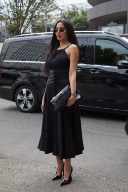 MİLAN, İTALYA 21 Eylül 2024: siyah elbiseli ve tüylü Zainab al Alwan Ferragamo defilesinden önce, Milan sokak tarzı