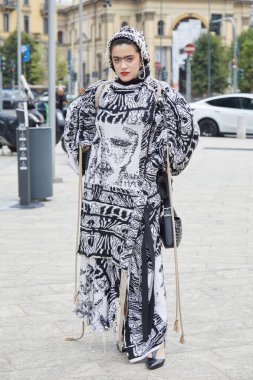 MİLAN, İTALYA 21 Eylül 2024 Ermanno Scervino defilesinden önce kapüşonlu siyah ve beyaz elbiseli kadın, Milano sokak tarzı