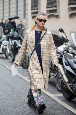 MILAN, İTALYA 20 Ocak 2025: Kareli ceketli ve renkli pantolonlu adam Giorgio Armani defilesinden önce, Milan Moda Haftası tarzı