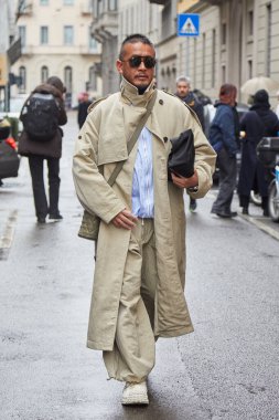 MİLAN, İTALYA 20 HAZİRAN 2025: bej renkli trençkotlu ve pantolonlu adam Giorgio Armani defilesinden önce, Milan Moda Haftası tarzı