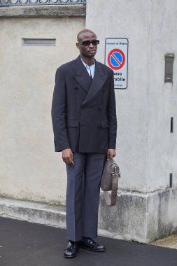 MİLAN, İTALYA 19 HAZİRAN 2025: Gri ceketli ve pantolonlu adam Prada defilesinden önce, Milan Moda Haftası tarzı