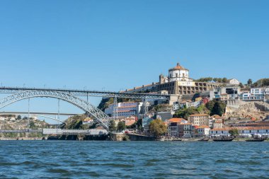 Porto, Portugal - September 26, 2022: partial view of the impressive Dom Luise I arch bridge connecting the historic district Ribeira and Vila Nova de Gaia neighborhood as seen from Douro River waters