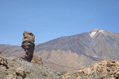 Solda Roque Cinchado ile Pico del Teide 'nin manzarası, Roques de Garcia' nın alışılmadık mineral oluşumu, doğal erozyon, Tenerife, Kanarya Adaları, İspanya tarafından yontulmuş bir dizi volkanik kaya dizisi.