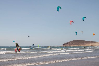 El Medano, Tenerife, Kanarya Adaları, İspanya - 21 Ağustos 2020: Mükemmel rüzgarlı bir günde su sporları yapan insanlar, tüm yıl boyunca ayrıcalıklı hava koşullarına sahip popüler turizm beldesi