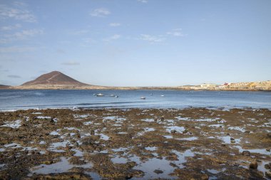 Her yıl Tenerife, Kanarya Adaları, İspanya 'da turistler tarafından ziyaret edilen, aileler ve su sporları meraklıları için uygun sonsuz gezintilere ve ulaşılabilir plajlara sahip sahil beldesinin sabah manzaraları