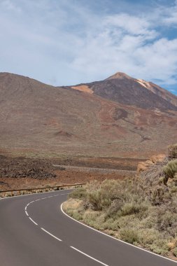 Önde gelen stratovolcano manzaralı ve volkanik arazi, Tenerife, Kanarya Adaları, İspanya ile çevrili ülkenin en yüksek zirvesi olan Teide Ulusal Parkı 'ndan geçen virajlı bir yol.