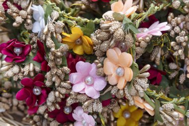 Tiny basket filled with gajra, garlands commonly used in Hindu weddings for decorative purposes, accessories made of fabric flowers and used by female guests or family in their hair or on their wrists clipart