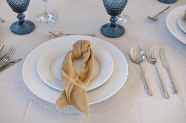 Düğünler, ziyafetler ya da üst üste örülmüş kumaş peçeteler, mavi su kadehleri ve gümüş çatal bıçakların yer aldığı üst düzey toplantılar için tasarlanmış masa düzenlemeleri