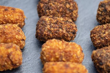 Yeni hazırlanmış ev yapımı İspanyol kroketleri koyu bir tabakta servis ediliyor. Lezzetli, bol yağda kızartılmış ekmek kırıntıları çeşitli dolgulu tapalar. Genellikle şarapla ya da birayla eşleşen lezzetli tapalar.