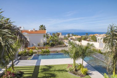 Geniş bir sonsuzluk yüzme havuzu, manzaralı tropikal bahçeler ve Tenerife, Kanarya Adaları 'ndaki La Gomera adası manzaralı modern bir araziden manzara.