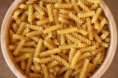 Büyük bir ahşap kasede pişirilmemiş fusilli makarna, Akdeniz mutfağında sarmal şekli ve sebze, et, peynir ve çeşitli soslarla pişirmede çok yönlü olmasıyla bilinen kuru bir malzeme.