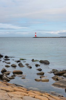 Baltık Denizi, Rostock, Mecklenburg-Vorpommern, Almanya 'ya tepeden bakan bir taş kırıcının sonundaki kentin ayırt edici deniz fenerlerinden birinin bulunduğu Warnemnde sahili.
