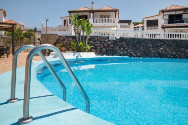 Paraiso Royal, Tenerife, Kanarya Adaları, İspanya - 22 Haziran 2025: Bereketli tropikal yeşillikler ve huzurlu bir atmosferle çevrili özel bir tatil tesisi içinde sakin bir yüzme havuzu