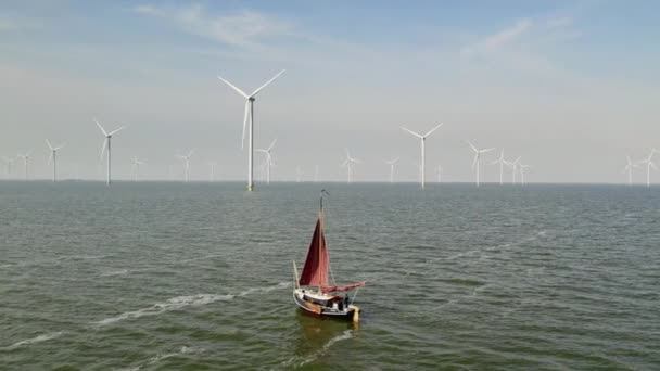 オランダの洋上風力発電所近くの歴史的な平底セーリング船の空中ビュー — ストック動画