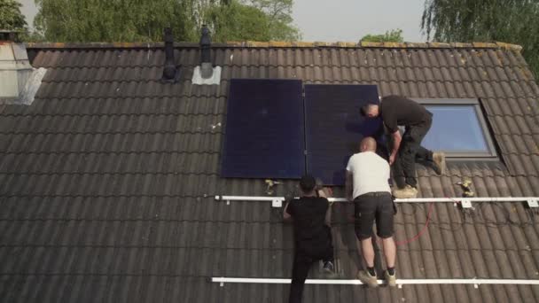 屋根を収容する太陽光写真の電圧パネルをフィッティングする技術者 — ストック動画