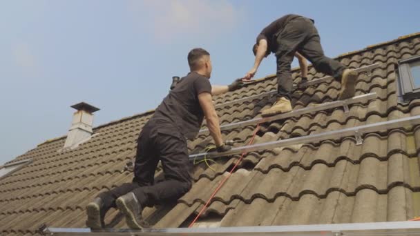 在屋顶上安装太阳能电池板架的技术人员 — 图库视频影像