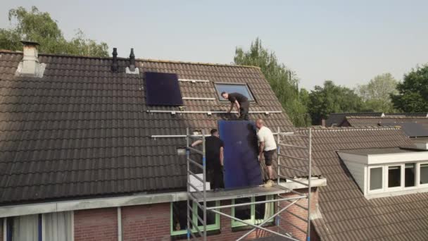 Τεχνικοί Που Τοποθετούν Ηλιακούς Φωτοβολταϊκούς Συλλέκτες Στη Στέγη Σπιτιών — Αρχείο Βίντεο