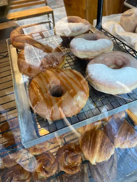 Tatlı çörekler, jöleli çörekler, pişmiş yiyecekler. Donut üretimi. Çörekler kızartılmış, jöleli ve bir donut fırınında raflara serilmiş..