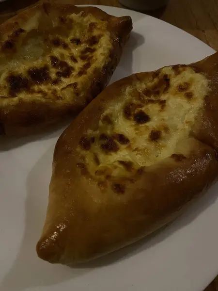 Yumurta sarısıyla servis edilen ev yapımı peynirli turta. İki geleneksel Gürcü Khachapuri 'nin yakın çekim görüntüsü.