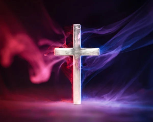 Religious cross emanating red and blue smoke symbolizing Heaven and Hell, good and evil, right and wrong, or other metaphor for moral choices.