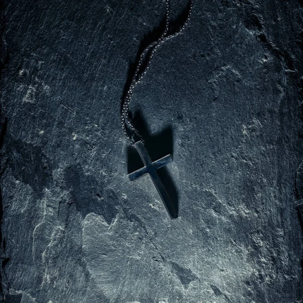 Křesťanský Kříž Náhrdelník Břidlicovém Pozadí Krucifix Vrhající Tmavý Stín — Stock fotografie