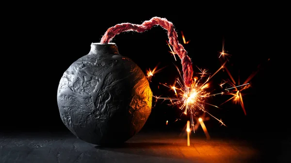 火のついた丸みを帯びた黒い爆弾は火花で燃えます または危険な暴力を象徴する爆弾を爆発させようとしている — ストック写真