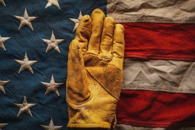 Eski Amerikan bayrağının üzerinde duran iş eldiveni. Amerikan işgücünü ya da işçi sınıfını kutlamak. ABD yapımı, veya İşçi Bayramı konsepti.