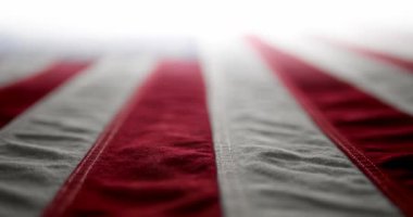 Işıl ışıl, kırmızı beyaz ve mavi bir Amerikan bayrağının üzerinde dalgalanan ve yavaşça beyaza dönüşen. Anma Günü için arka plan, Gaziler Günü, 4 Temmuz, ya da başka bir vatansever ABD tatili.