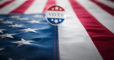Amerika Birleşik Devletleri 'nin kırmızı beyaz ve mavi rozetli, Amerikan bayrağına iğnelenmiş olarak oy verin. ABD seçimlerinde oy kullanma, ulusal gurur ve siyasi müdahaleyi teşvik etmek için. ABD 'de demokrasiyi temsil ediyor..
