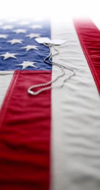 Kırmızı beyaz ve mavi Amerikan bayrağında parlak askeri künyeler. Birleşik Devletler Anma Günü, Silahlı Kuvvetler Günü, Gaziler Günü ya da diğer vatansever ABD bayramları için arka plan.