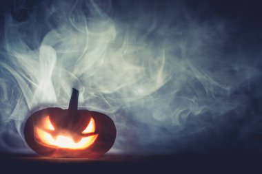 Korkunç Cadılar Bayramı Jack o fener kabağı oyulmuş korkunç sırıtan yüzüyle Cadılar Bayramı gecesi dumanında parlayan.