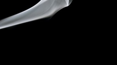 Yumuşak ruhani şekillerde yanan ve dönen yatay duman. Siyah arkaplanda gerçek duman, sol üst kenarda.