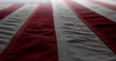 Parlak, kırmızı, beyaz ve mavi bir Amerikan bayrağının üzerinde dalgalanıyor. Anma Günü için arka plan, Gaziler Günü, 4 Temmuz, ya da başka bir vatansever ABD tatili.