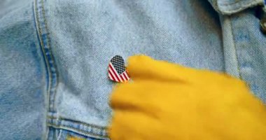 Amerikan mavi yakalı işçi, Amerikan bayrağıyla kalp şeklinde parlak yaka iğnesi takıyor. Vatanseverliği kutlamak, İşçi Bayramı, Amerika 'da üretim, ya da başka bir vatansever ABD tatili..