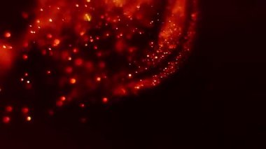 Havada süzülen kızgın közlerin cehennemi. Parlak kıvılcımlar saçan parlak bokeh partiküllerin girdap ve yanmasından oluşan cehennem ateşini yaratıyor. Döngü dinamik hareketi ile cehennem soyut arkaplan.