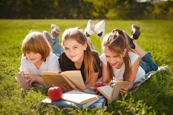 孩子们在绿草上排成行 课后在公园看书 — 图库照片