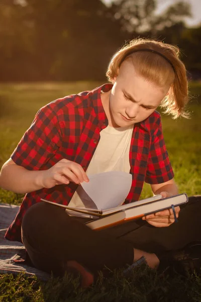 student boy study up in green park alone, study outdoors in university campus